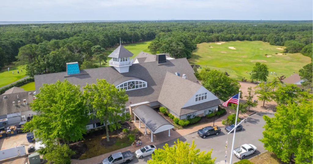 Aerial view of LBI National Golf & Resort clubhouse with fairways and Pinelands backdrop in Little Egg Harbor, NJ, owned by Accountable Equity and operated by Vivamee Hospitality