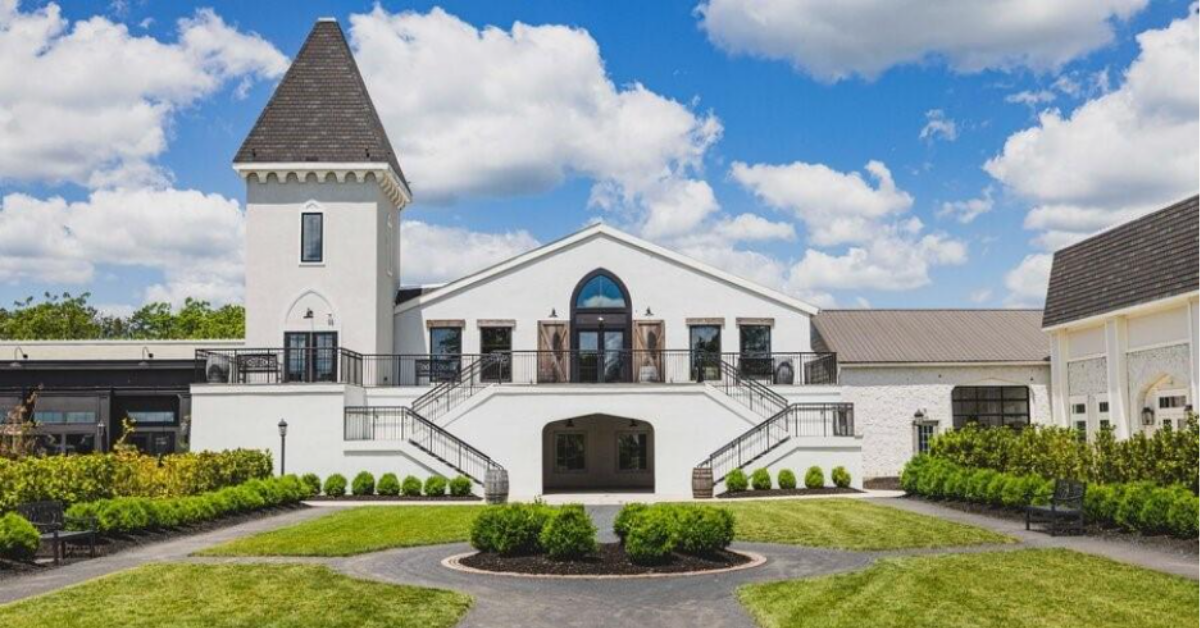 Exterior photograph of the Vineyard Ballroom and Noelle's Tower at Renault Winery Resort, a destination hospitality property in the Accountable Equity portfolio, showing the grand white facade, symmetrical staircases, and manicured courtyard.