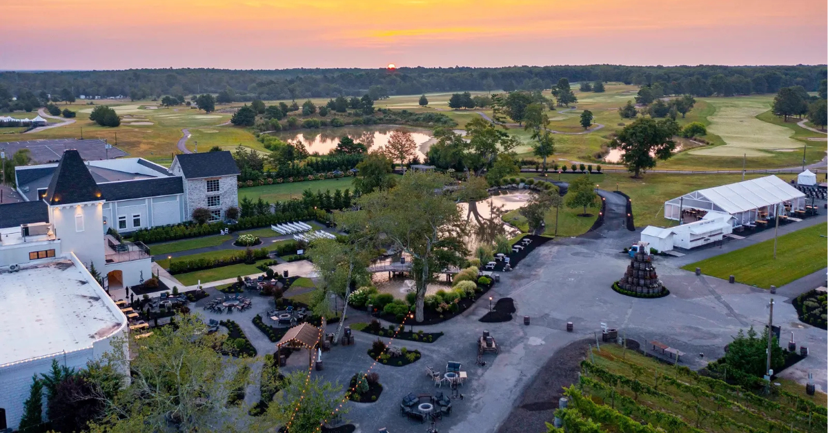 renault-winery-resort-sunrise-vineyard-golf-course.jpg Aerial sunrise view of Renault Winery Resort in Egg Harbor City, NJ, showing outdoor event venues, vineyard rows, and the Vineyard National Golf Course, operated by Vivamee Hospitality