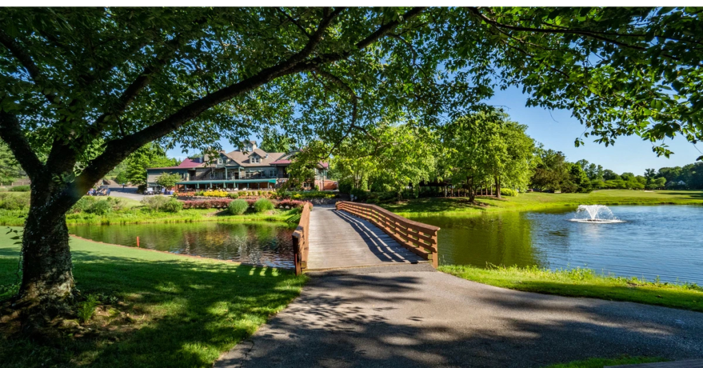 golf-club-south-river-bridge-clubhouse.webp A wooden bridge leads over a pond toward the clubhouse at Golf Club at South River in Edgewater, Maryland — a destination golf and hospitality property whose assets are owned by the funds offered by Accountable Equity and operated by Vivamee Hospitality.
