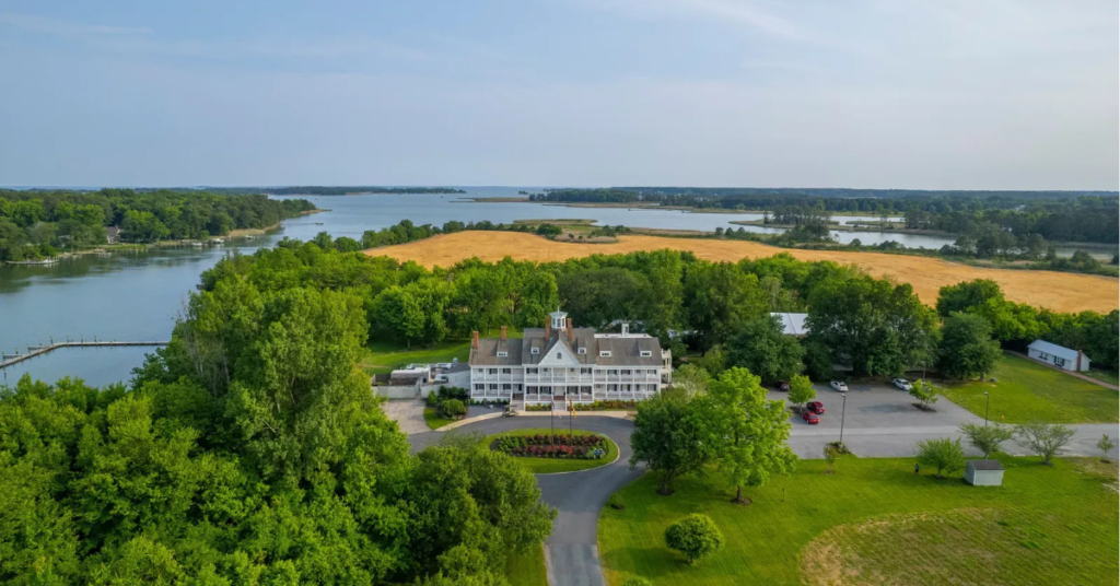 Aerial view of Kent Island Resort showing the historic manor house and waterfront setting in Stevensville, Maryland, illustrating the tangible scale of destination hospitality real assets
