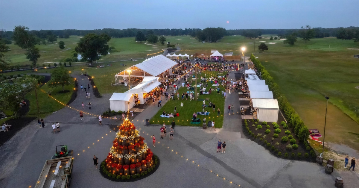 outdoor-event-parc-renault-winery-resort-aerial.jpg Aerial view of an outdoor experiential event at Renault Winery Resort with hundreds of guests, tented venues, string lights, and golf course in the background